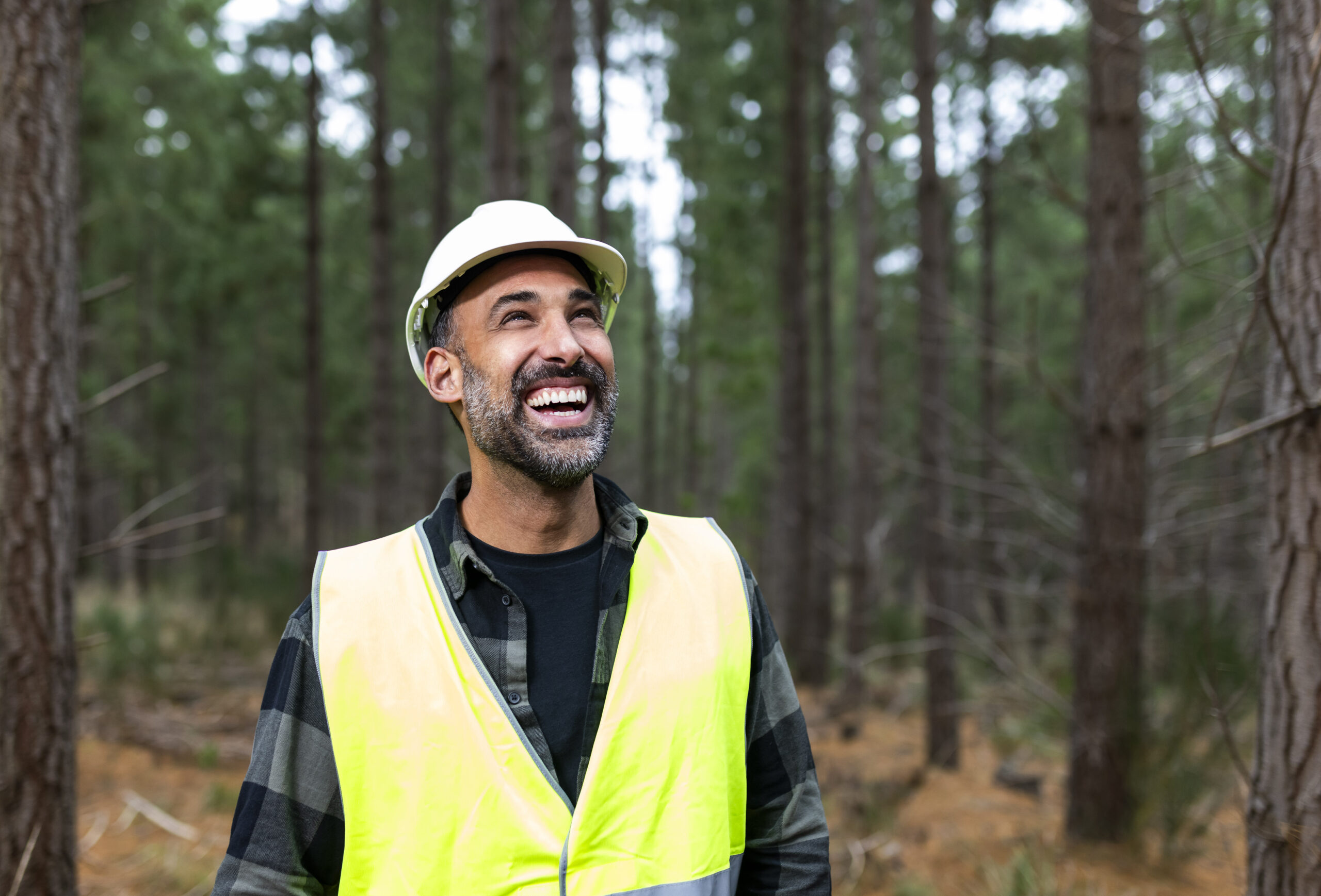 Photo of brand ambassador Adam Dovile wearing PPE in a pine forest while on set of the 2023 The Ultimate Renewable™ campaign