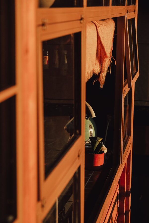 Shadow cast across a butchers's cabinet filled with trinkets